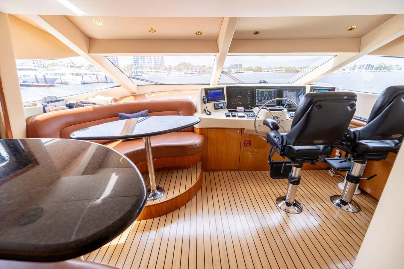 The helm area features luxurious seating and state-of-the-art navigation equipment. aboard OUTRAGEOUS Yacht for Sale
