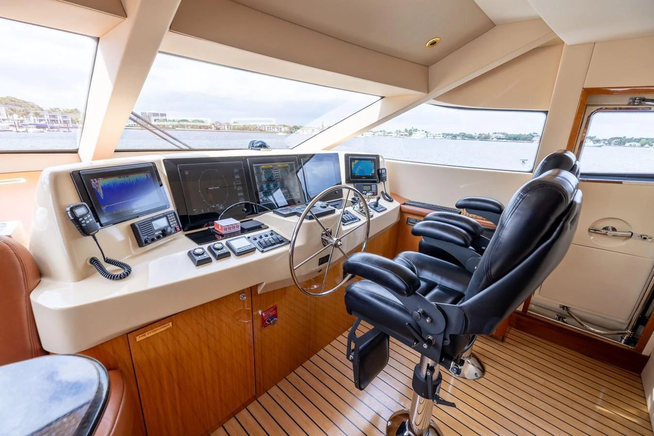 The helm station features advanced navigation equipment and comfortable seating with a panoramic view. aboard OUTRAGEOUS Yacht for Sale