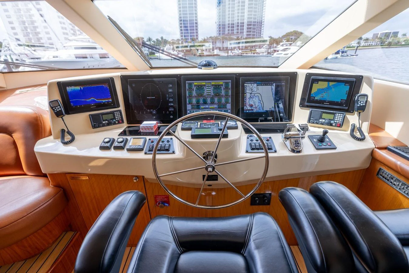 The helm station features advanced navigation equipment and luxurious seating, offering a commanding view of the surroundings. aboard OUTRAGEOUS Yacht for Sale