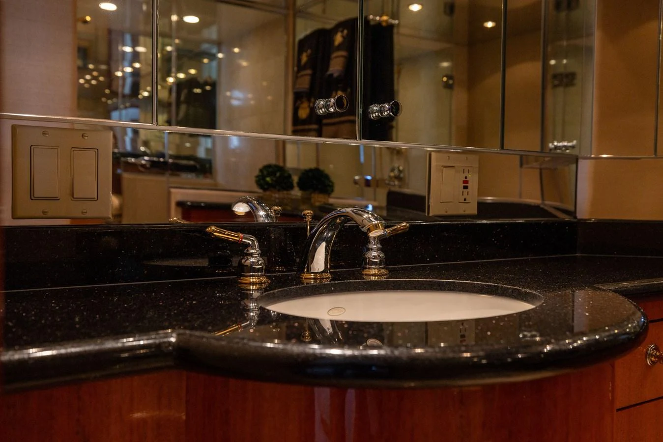 The bathroom features elegant fixtures and a sleek countertop, exuding luxury and sophistication. aboard OUTRAGEOUS Yacht for Sale