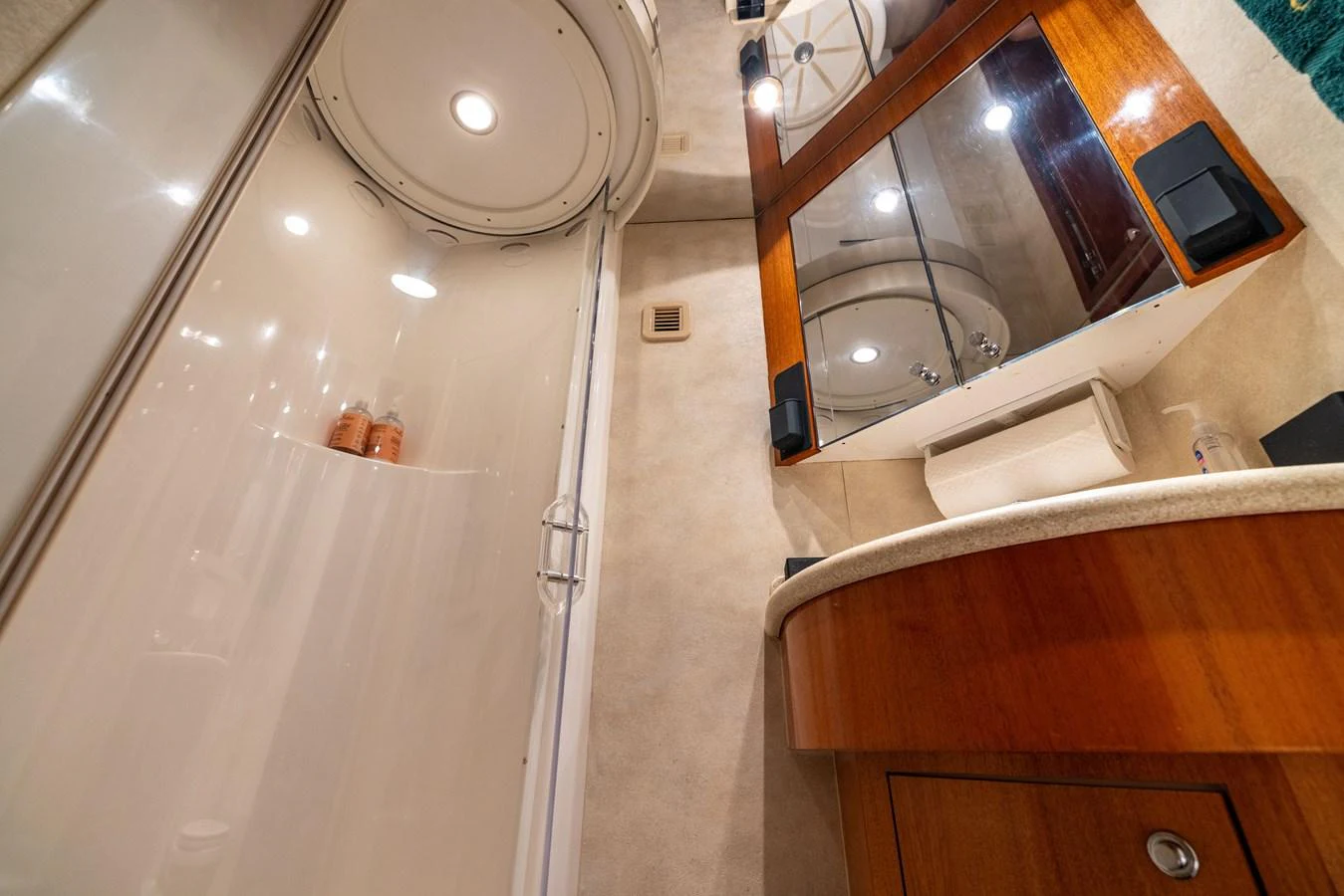 The yacht's bathroom features a sleek shower and elegant wooden cabinetry. aboard OUTRAGEOUS Yacht for Sale