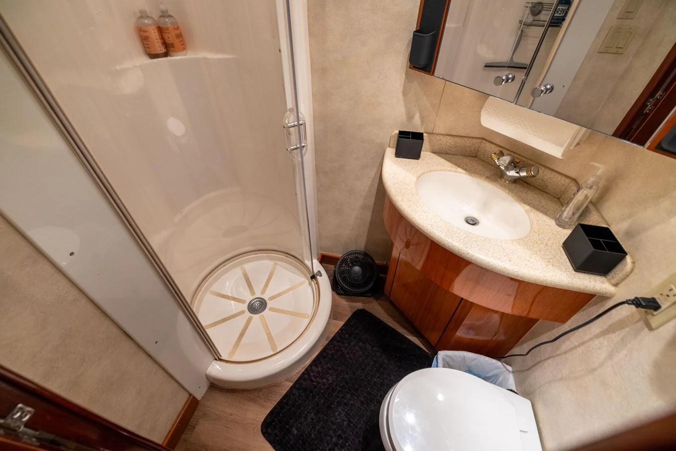 The yacht's bathroom features a compact shower, sink, and toilet with modern fixtures. aboard OUTRAGEOUS Yacht for Sale