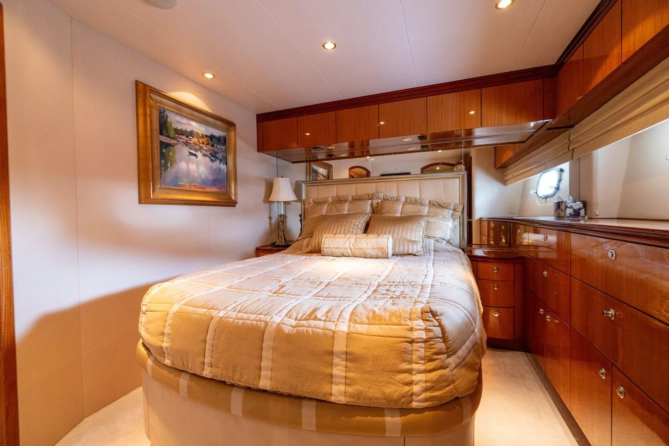 The stateroom features a plush bed with elegant wood cabinetry and soft lighting. aboard OUTRAGEOUS Yacht for Sale