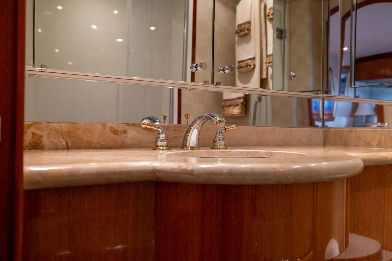The yacht's bathroom features a luxurious marble countertop with elegant fixtures. aboard OUTRAGEOUS Yacht for Sale