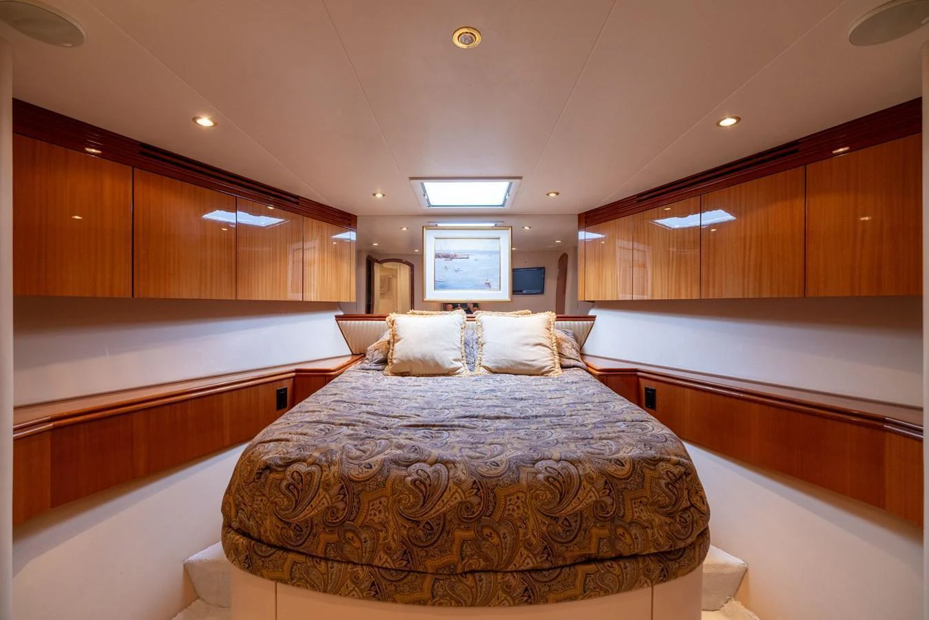 The stateroom features a cozy bed with elegant bedding and ample storage space. aboard OUTRAGEOUS Yacht for Sale