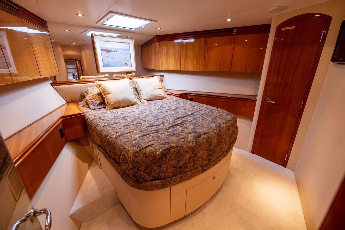 A luxurious stateroom with a plush bed and elegant wood finishes. aboard OUTRAGEOUS Yacht for Sale