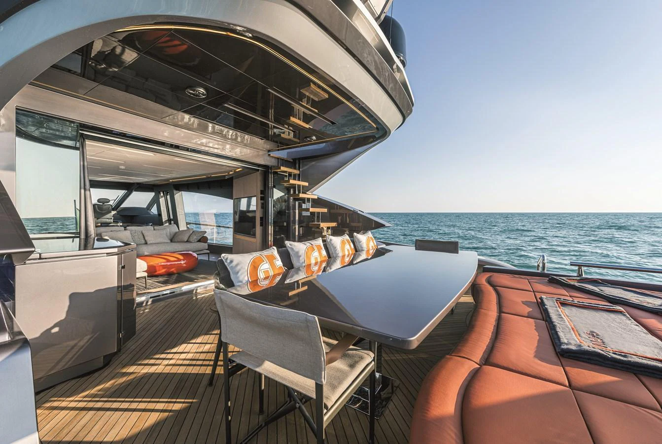 The aft deck features a stylish outdoor dining area with comfortable seating and a view of the sea. aboard AB 80 Yacht for Sale