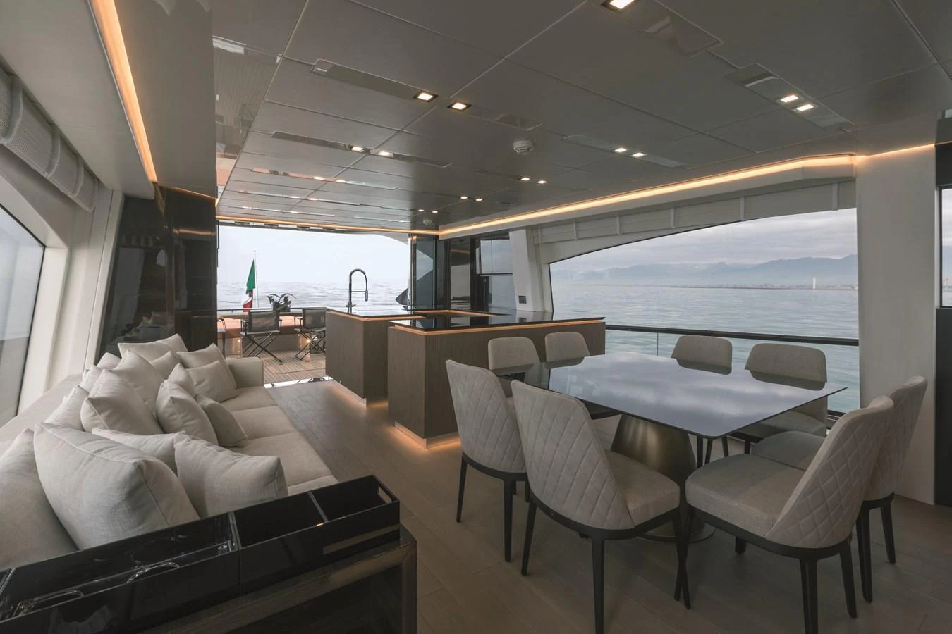 The salon offers a spacious and elegant area with comfortable seating and a dining table, complemented by panoramic views. aboard AB 80 Yacht for Sale