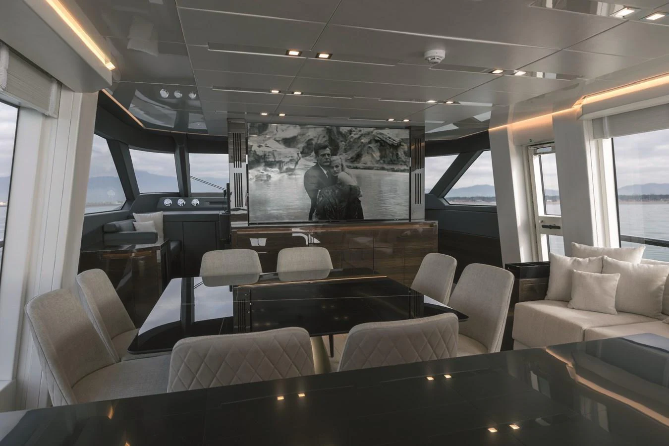 The salon features a modern and luxurious seating area with a large TV screen and panoramic windows. aboard AB 80 Yacht for Sale