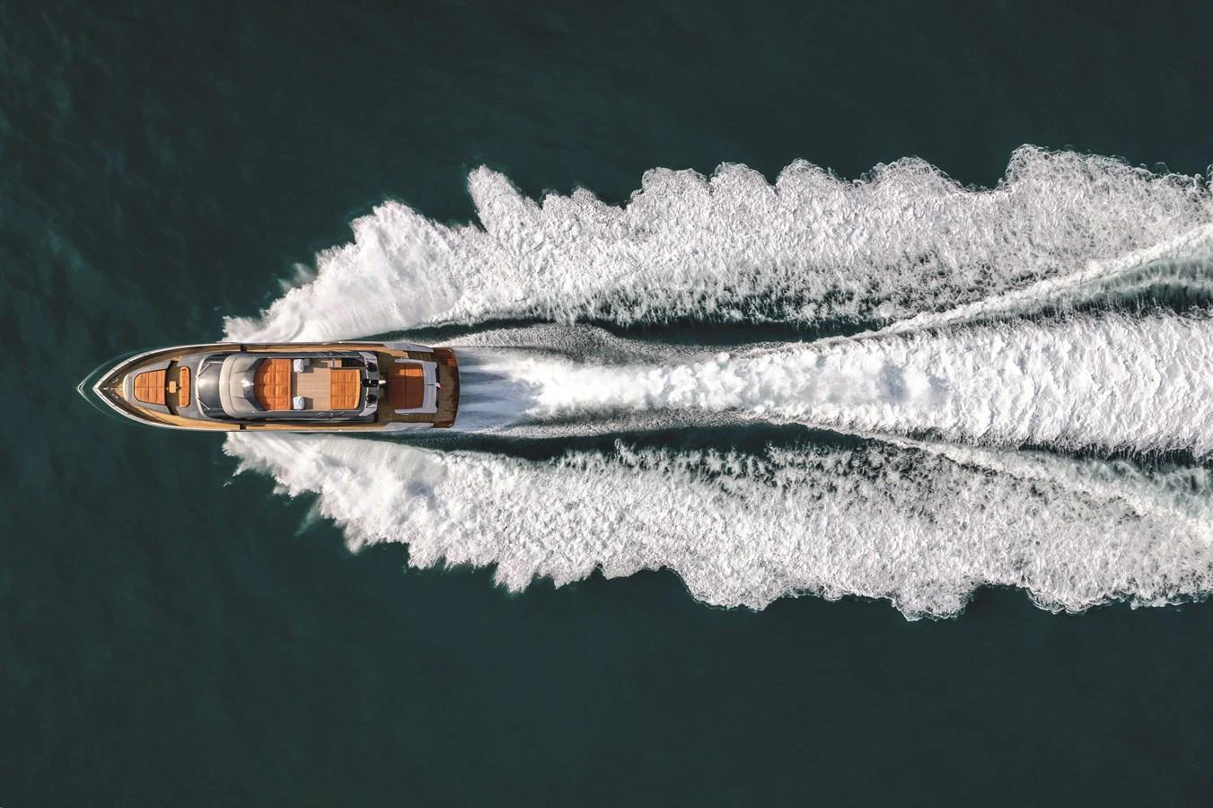 A sleek yacht cruises swiftly through the water, leaving a trail of white wake behind. aboard AB 80 Yacht for Sale