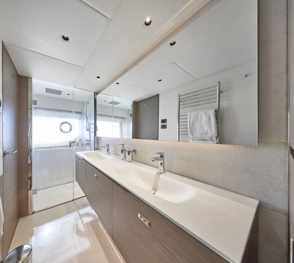 The yacht's bathroom features a sleek double sink vanity with modern fixtures and ample lighting. aboard POLARIS Yacht for Sale