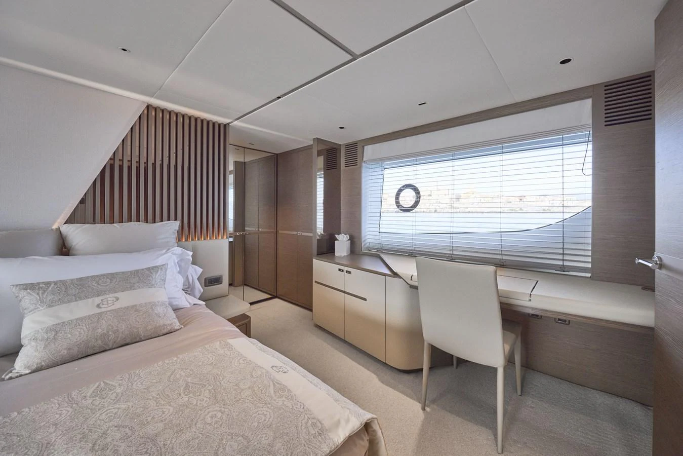 A luxurious stateroom featuring a comfortable bed and a stylish desk area with ample natural light. aboard POLARIS Yacht for Sale