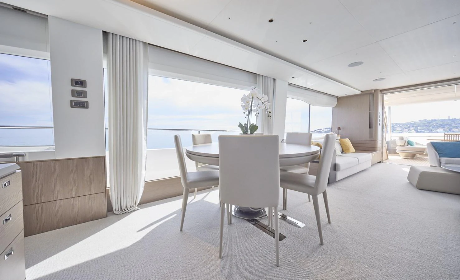 The yacht's dining area features a modern table with plush seating, surrounded by large windows offering stunning sea views. aboard POLARIS Yacht for Sale