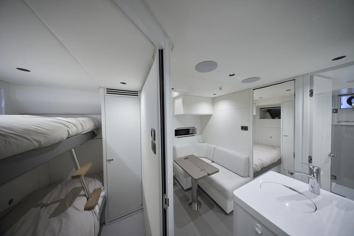 The yacht's cabin features a cozy dining area, bunk beds, and a compact bathroom, all designed with modern, minimalist aesthetics. aboard POLARIS Yacht for Sale