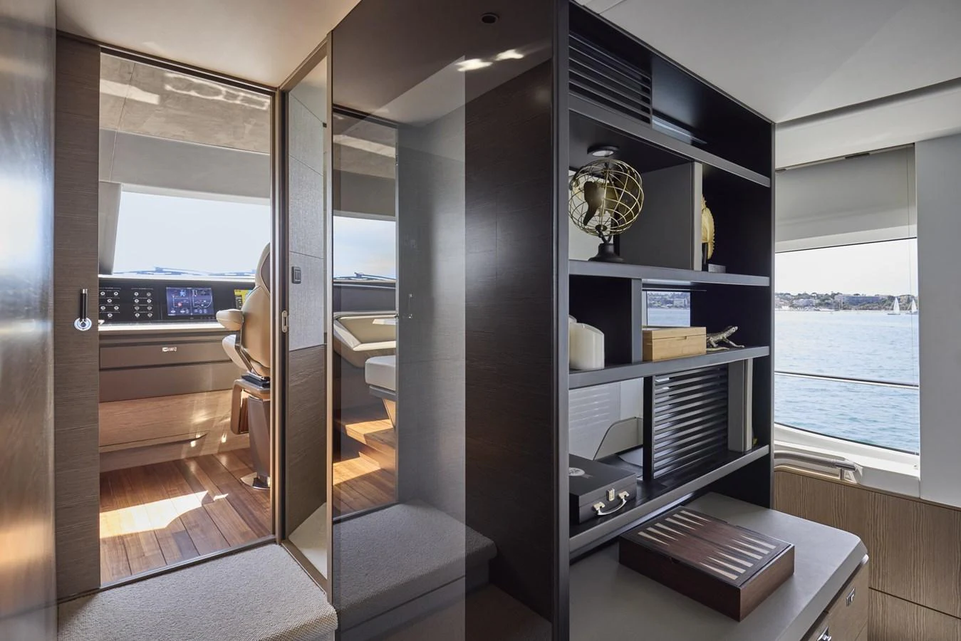 The image showcases a stylish and modern interior space with a view of the helm station through a glass door. aboard POLARIS Yacht for Sale