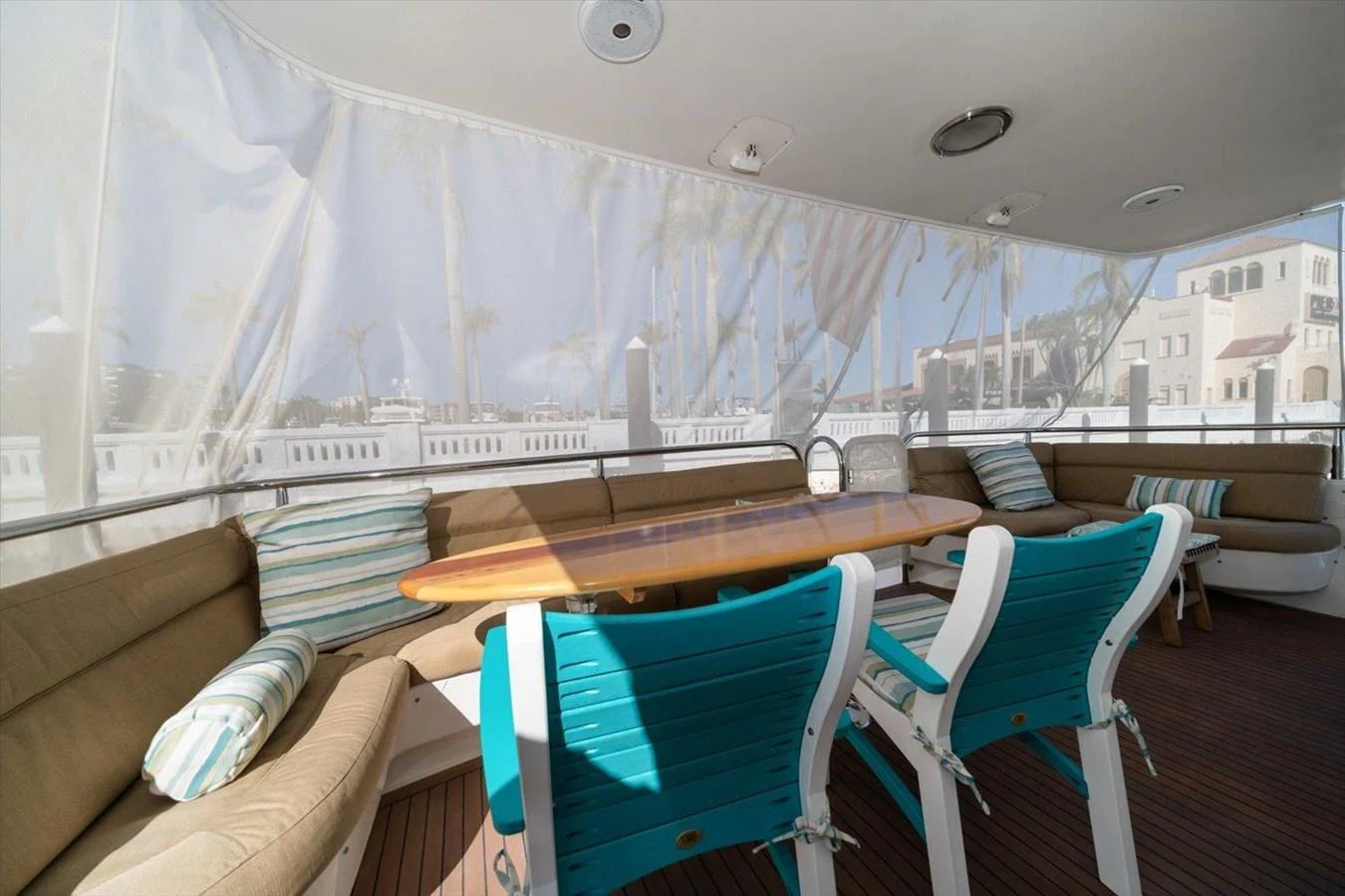 The aft deck features a cozy seating area with a wooden table and comfortable chairs, perfect for outdoor dining. aboard OCTOPI Yacht for Sale