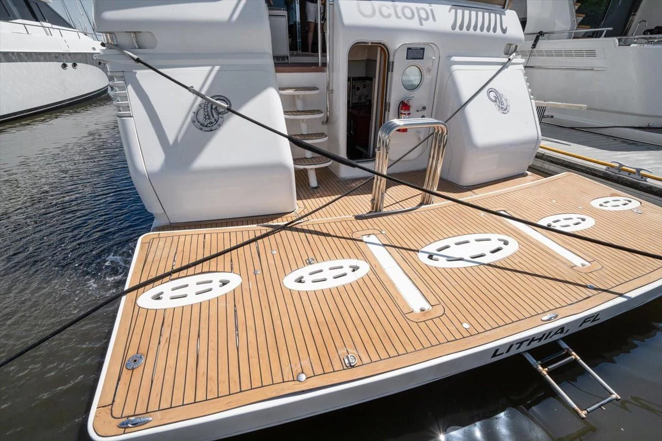 The aft deck of the yacht features a spacious teak platform with access to the water. aboard OCTOPI Yacht for Sale