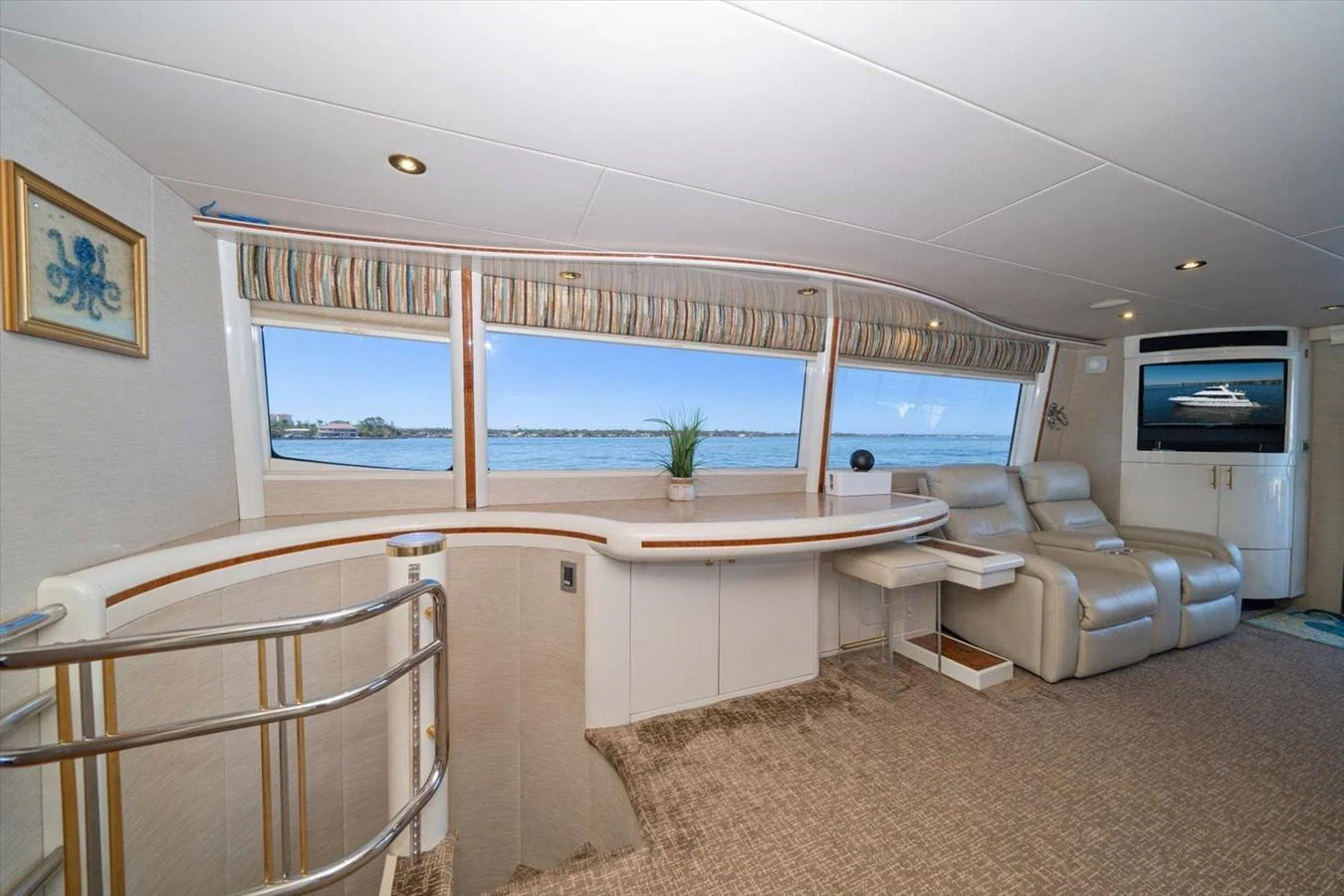 The salon features comfortable seating with a scenic view through large windows. aboard OCTOPI Yacht for Sale