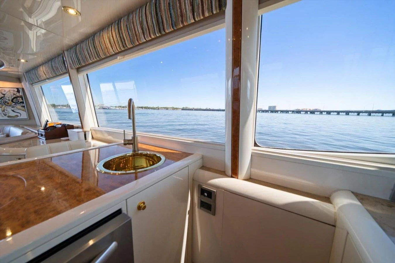 The yacht's galley offers a stunning view of the water through large windows, featuring a sleek countertop and modern fixtures. aboard OCTOPI Yacht for Sale
