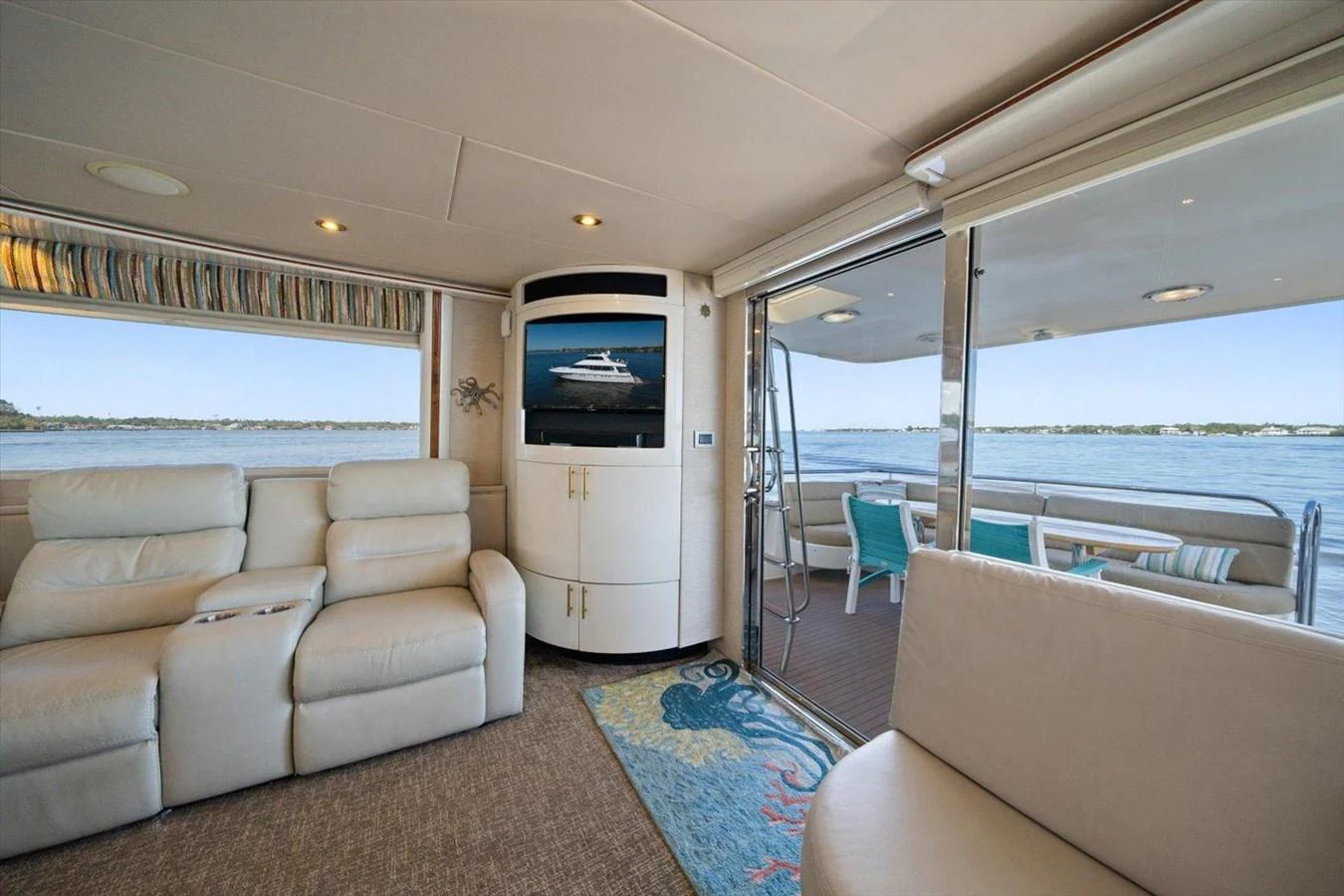 The salon offers a comfortable seating area with a view of the water through large sliding glass doors. aboard OCTOPI Yacht for Sale