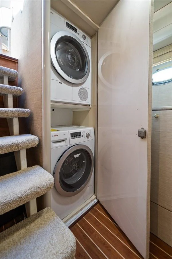 The yacht features a compact laundry area with a stacked washer and dryer unit. aboard OCTOPI Yacht for Sale