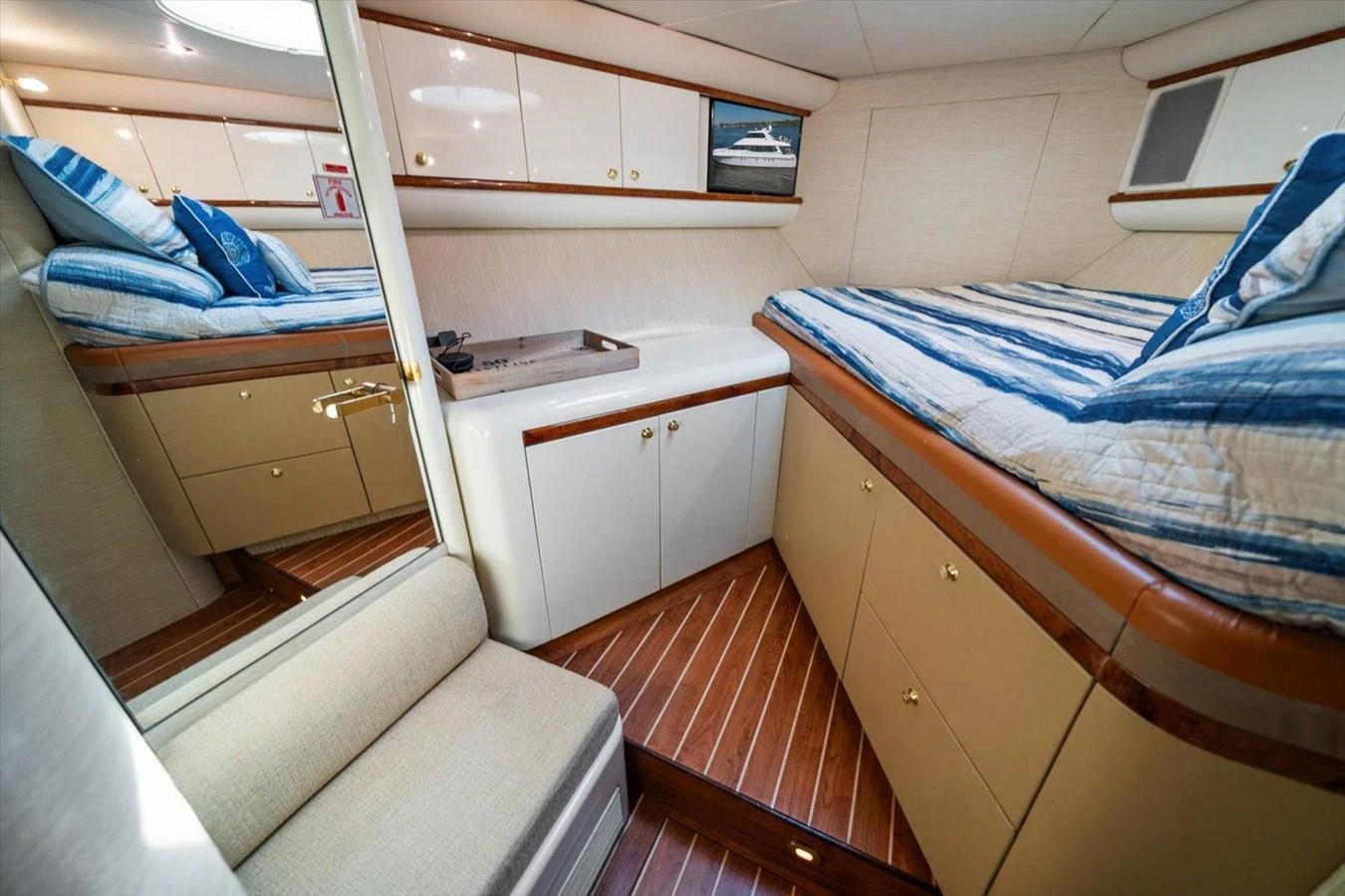 This cozy cabin features twin beds with striped bedding and ample storage space. aboard OCTOPI Yacht for Sale