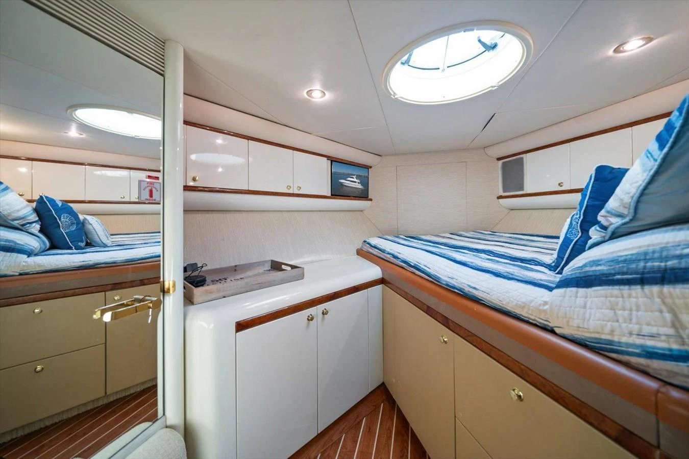 This cozy cabin features twin beds with striped bedding and ample storage space. aboard OCTOPI Yacht for Sale