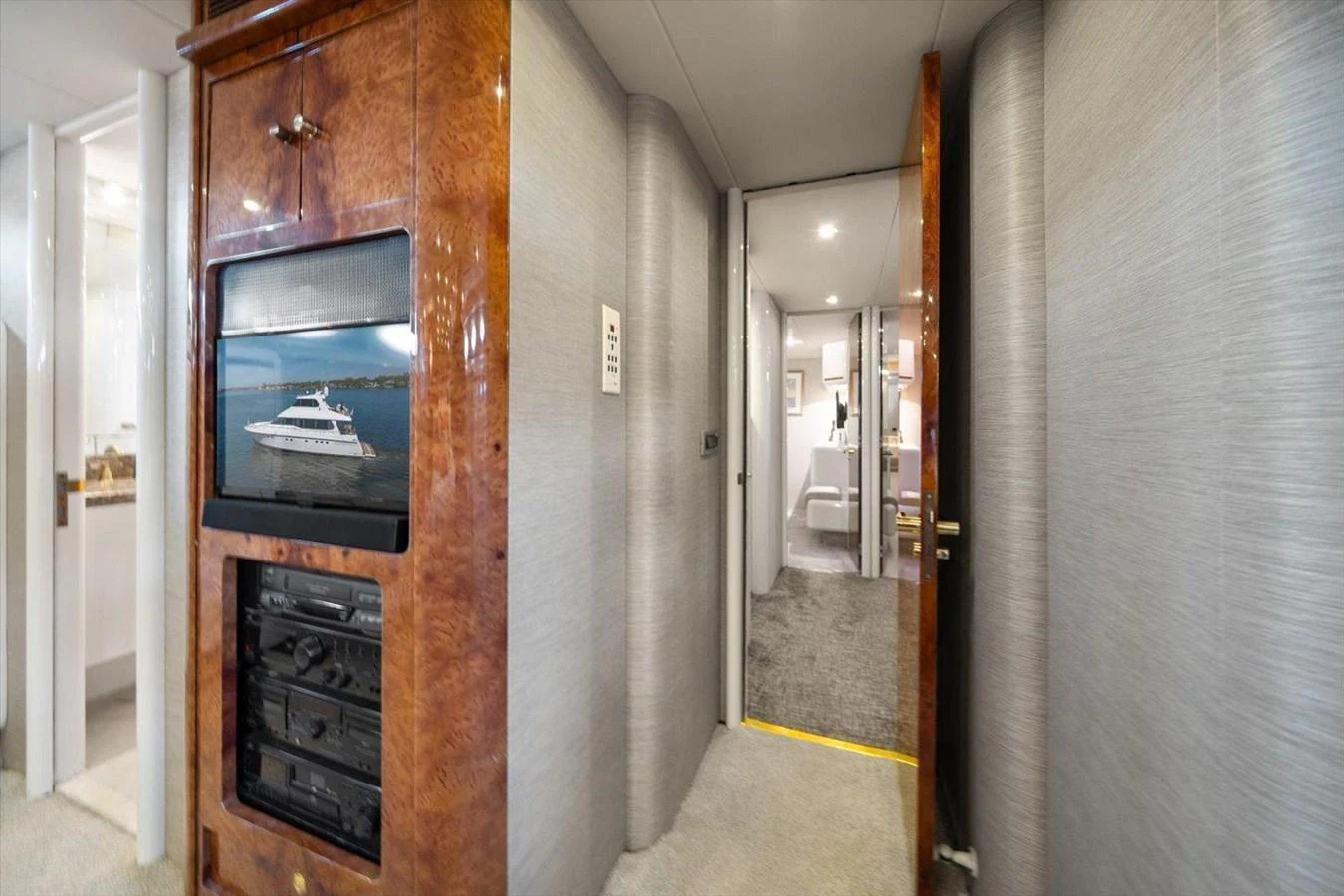 A luxurious hallway with a built-in entertainment system and access to other rooms. aboard OCTOPI Yacht for Sale