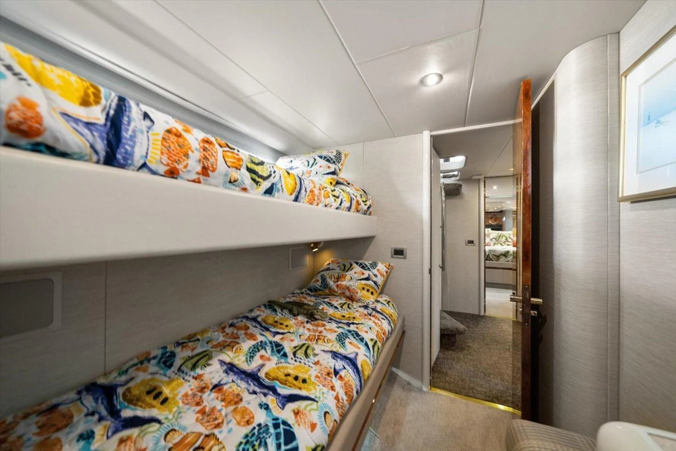 The guest cabin features cozy bunk beds with vibrant bedding and a modern, inviting decor. aboard OCTOPI Yacht for Sale