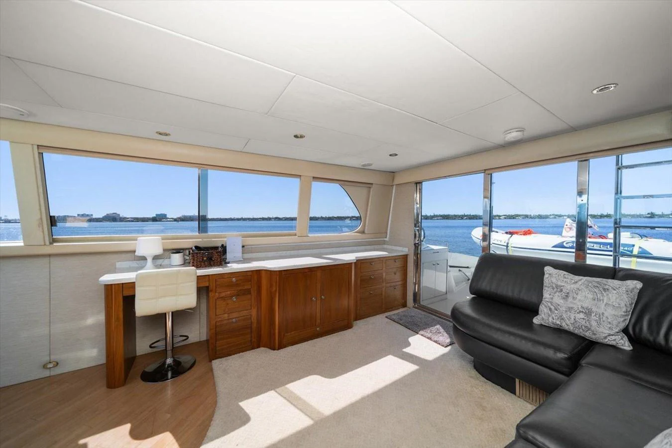 The salon features a comfortable seating area with panoramic windows offering stunning water views. aboard OCTOPI Yacht for Sale