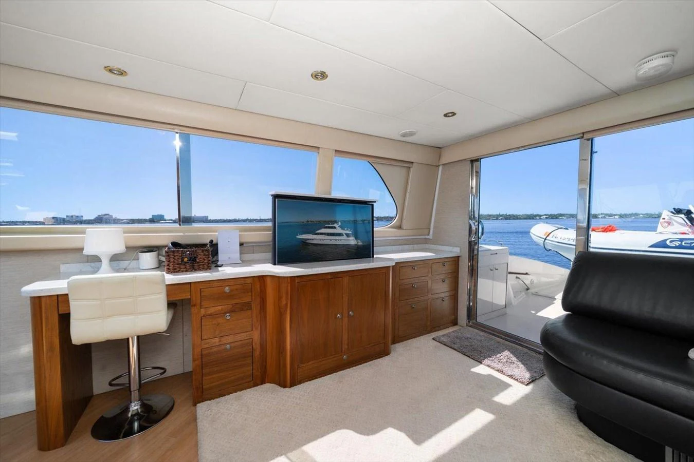 The salon features a comfortable seating area with a desk and large windows offering stunning views. aboard OCTOPI Yacht for Sale