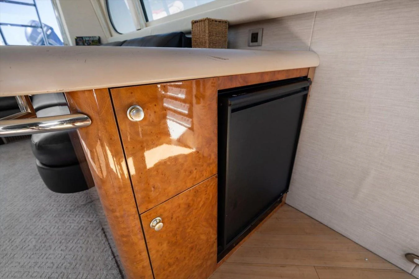 The yacht's galley features a compact refrigerator and elegant wood cabinetry. aboard OCTOPI Yacht for Sale