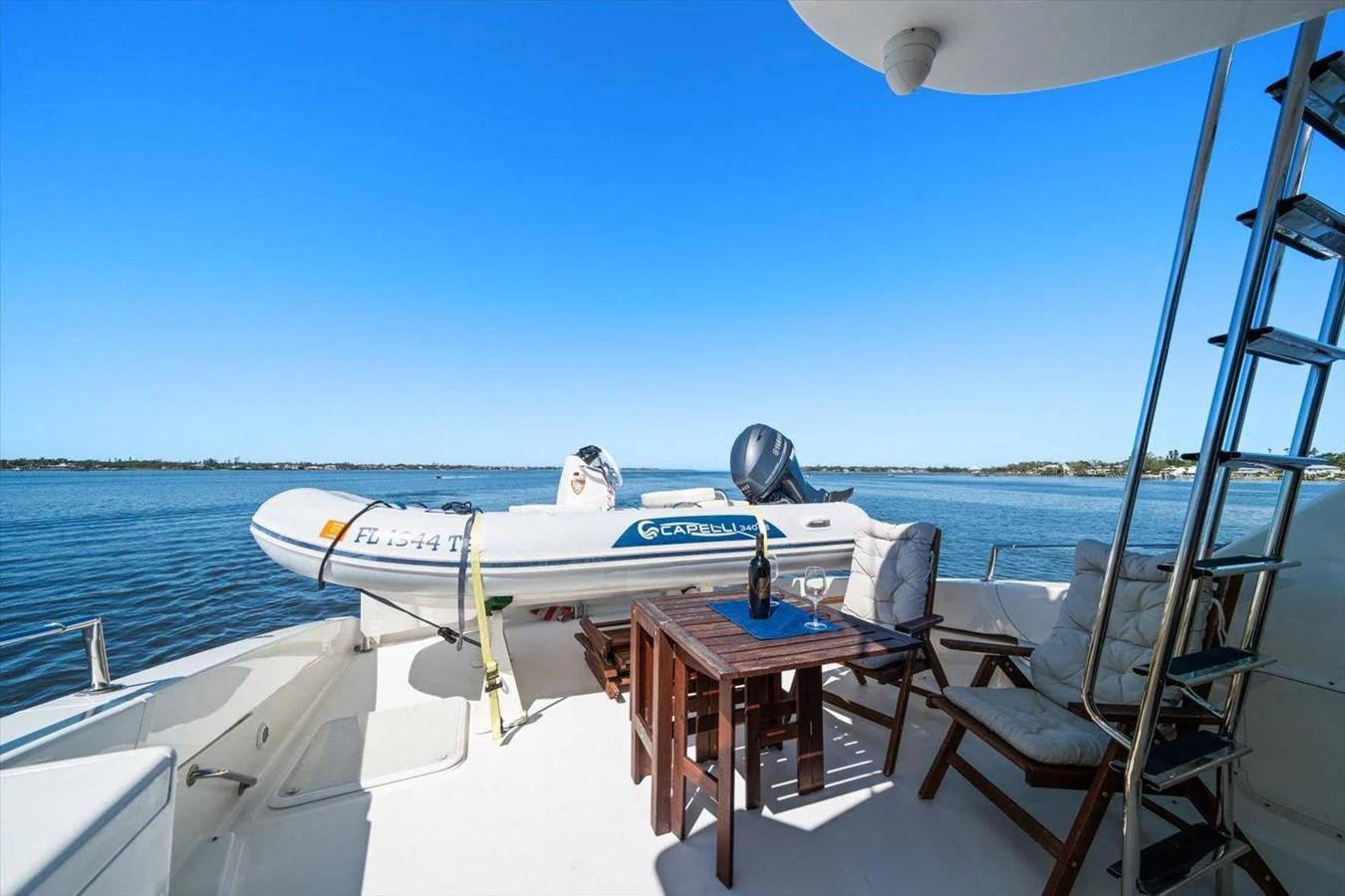 The aft deck offers a relaxing space with a tender and seating area overlooking serene waters. aboard OCTOPI Yacht for Sale
