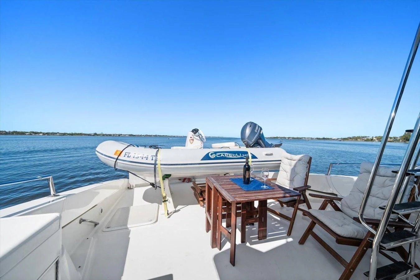 The aft deck features a comfortable seating area with a table, perfect for enjoying drinks while overlooking the water. aboard OCTOPI Yacht for Sale