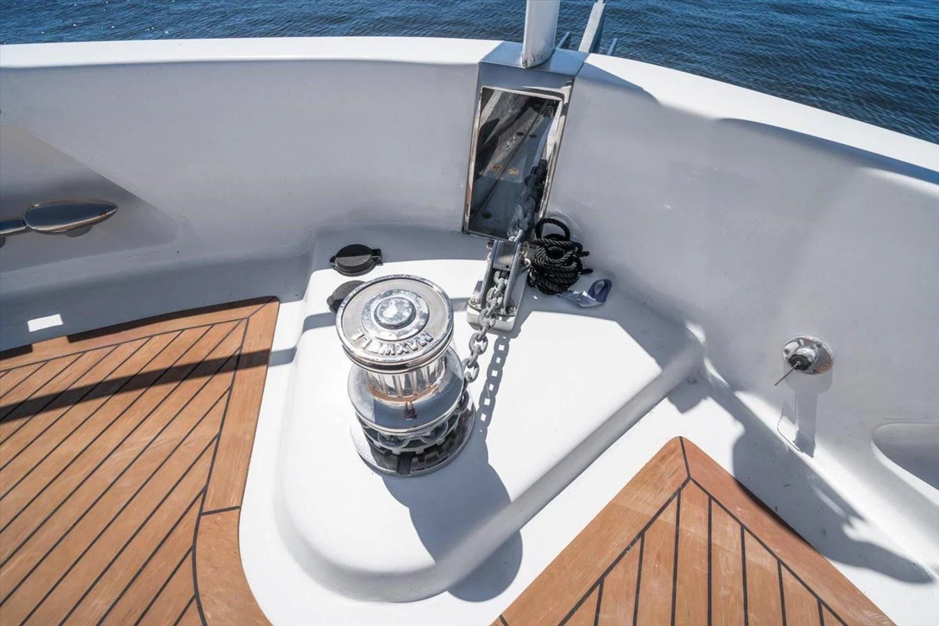 The image showcases a detailed view of the yacht's anchor winch system on a teak deck. aboard OCTOPI Yacht for Sale
