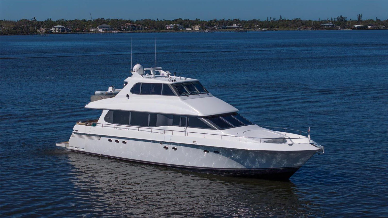 A sleek white yacht glides gracefully on calm blue waters, showcasing its elegant design. aboard OCTOPI Yacht for Sale