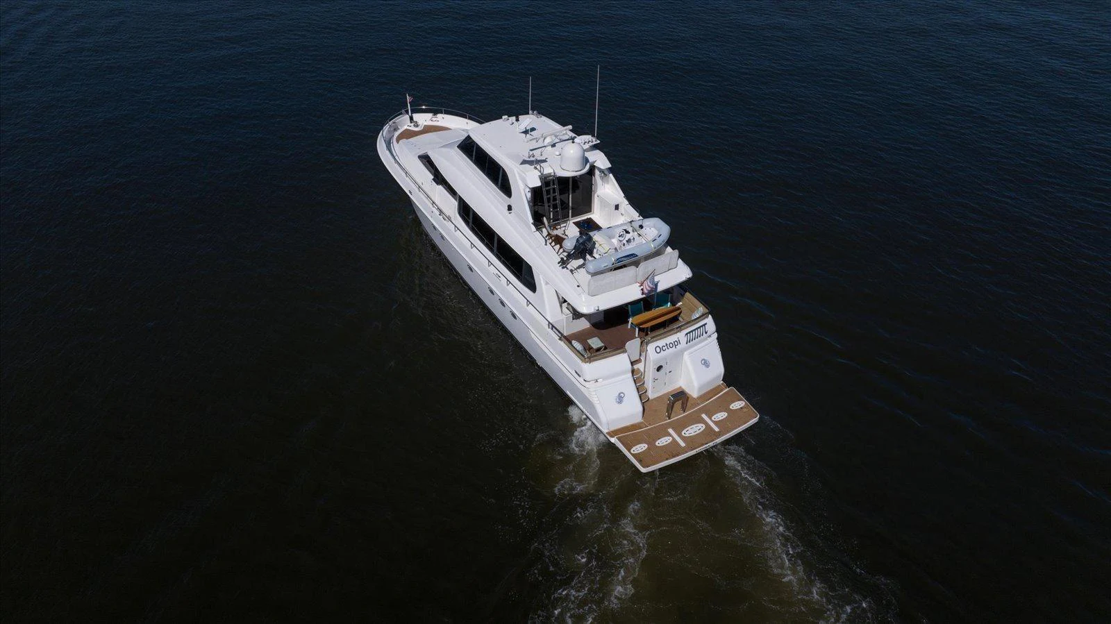 A luxurious yacht cruises through calm waters, showcasing its sleek design and spacious deck areas. aboard OCTOPI Yacht for Sale