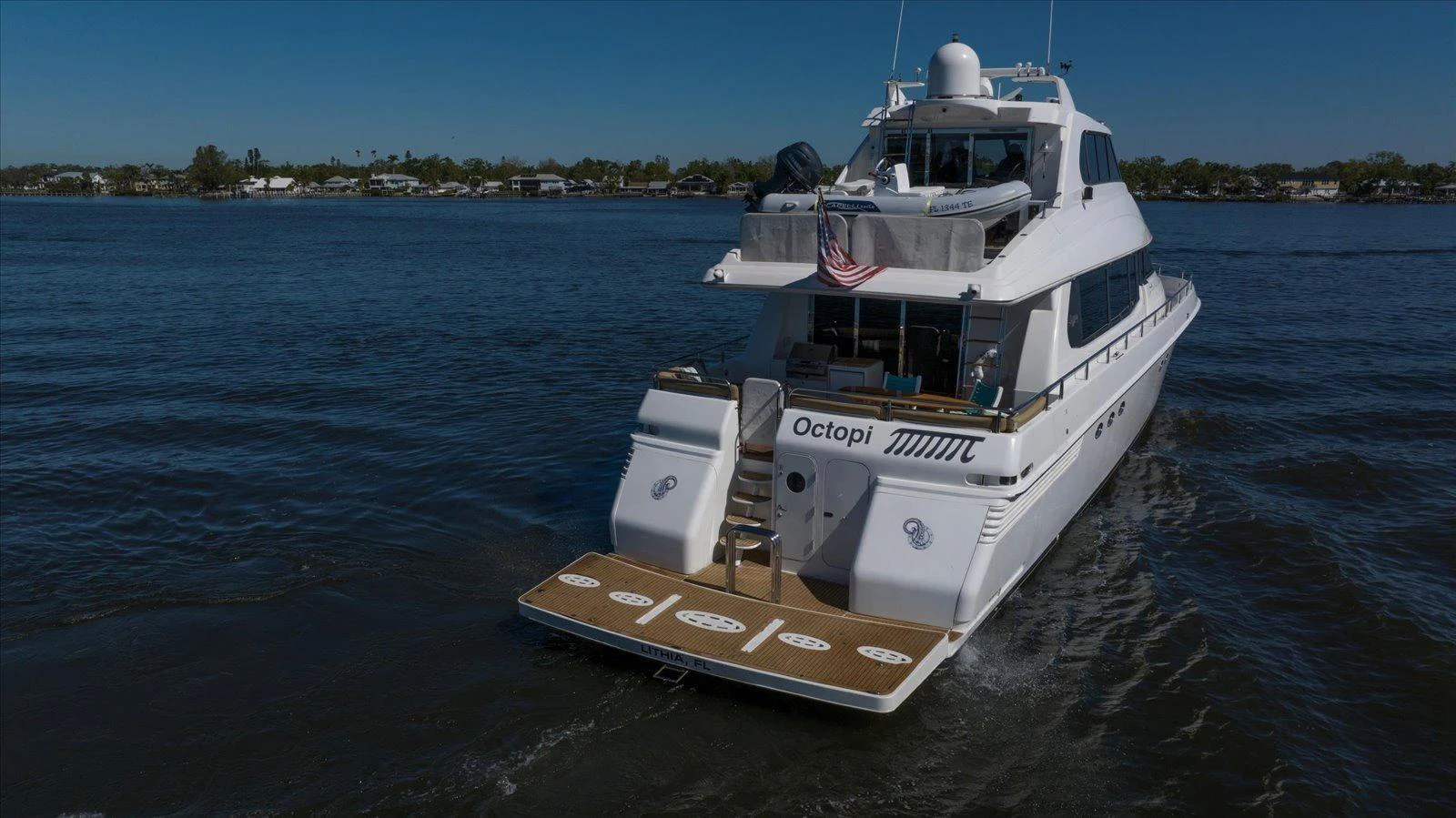 A luxurious yacht cruises on calm waters, showcasing its elegant design and spacious deck. aboard OCTOPI Yacht for Sale