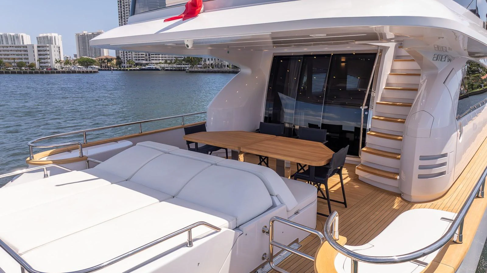 The aft deck features a comfortable lounging area and an elegant dining space with a view of the water. aboard SEA METRI V Yacht for Sale