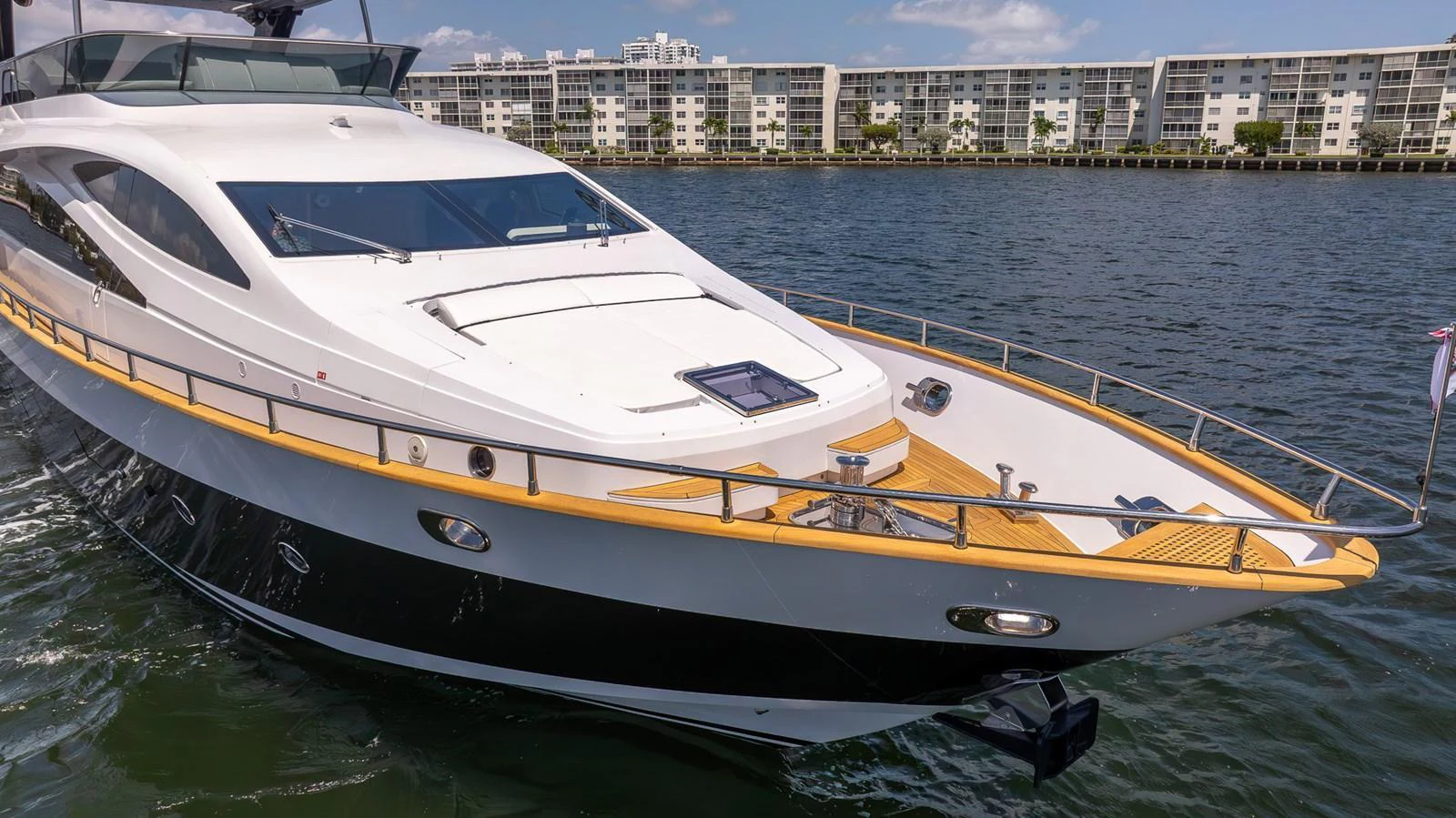 A sleek and modern yacht cruising on calm waters with a cityscape in the background. aboard SEA METRI V Yacht for Sale