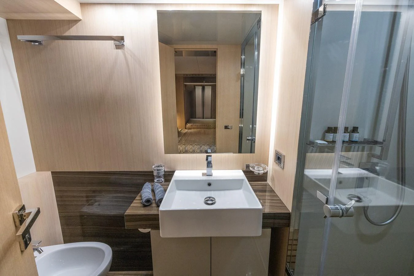 A modern yacht bathroom featuring a sleek sink, glass shower, and elegant lighting. aboard SEA METRI V Yacht for Sale