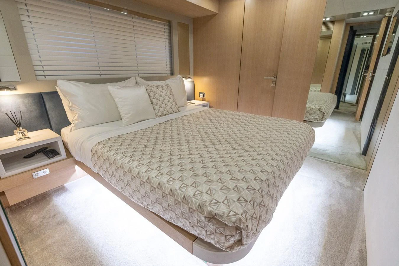 The stateroom features a luxurious bed with elegant bedding and ambient lighting. aboard SEA METRI V Yacht for Sale