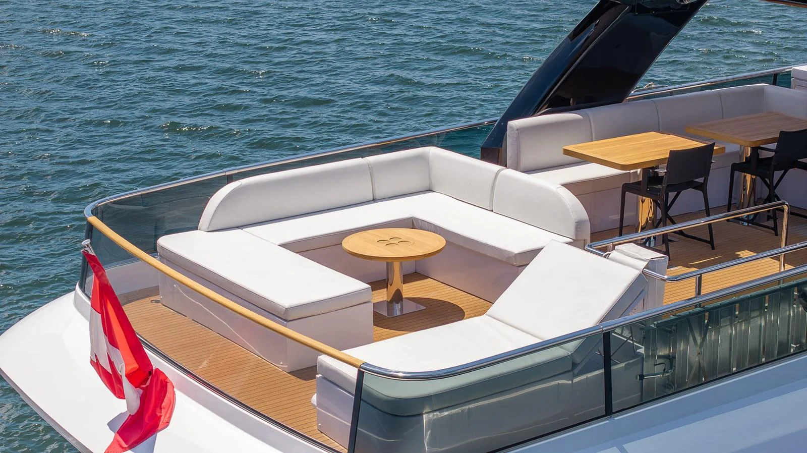 The aft deck offers a spacious seating area with a central table, perfect for outdoor relaxation and dining. aboard SEA METRI V Yacht for Sale