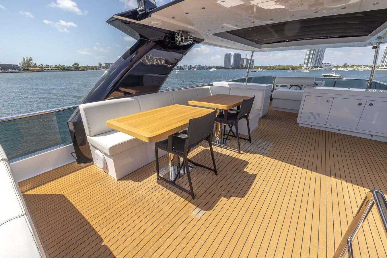 The aft deck features a spacious seating area with wooden tables, perfect for outdoor dining and relaxation. aboard SEA METRI V Yacht for Sale