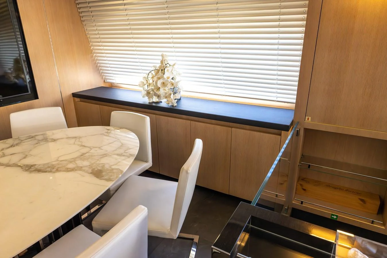 The yacht's interior features a stylish dining area with a marble table and modern white chairs. aboard SEA METRI V Yacht for Sale