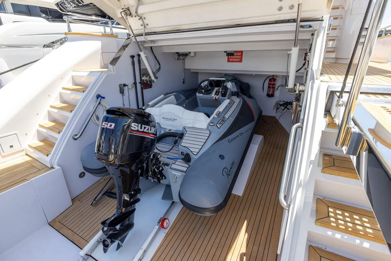 The image showcases a neatly stored tender with a powerful outboard motor in the yacht's garage. aboard SEA METRI V Yacht for Sale