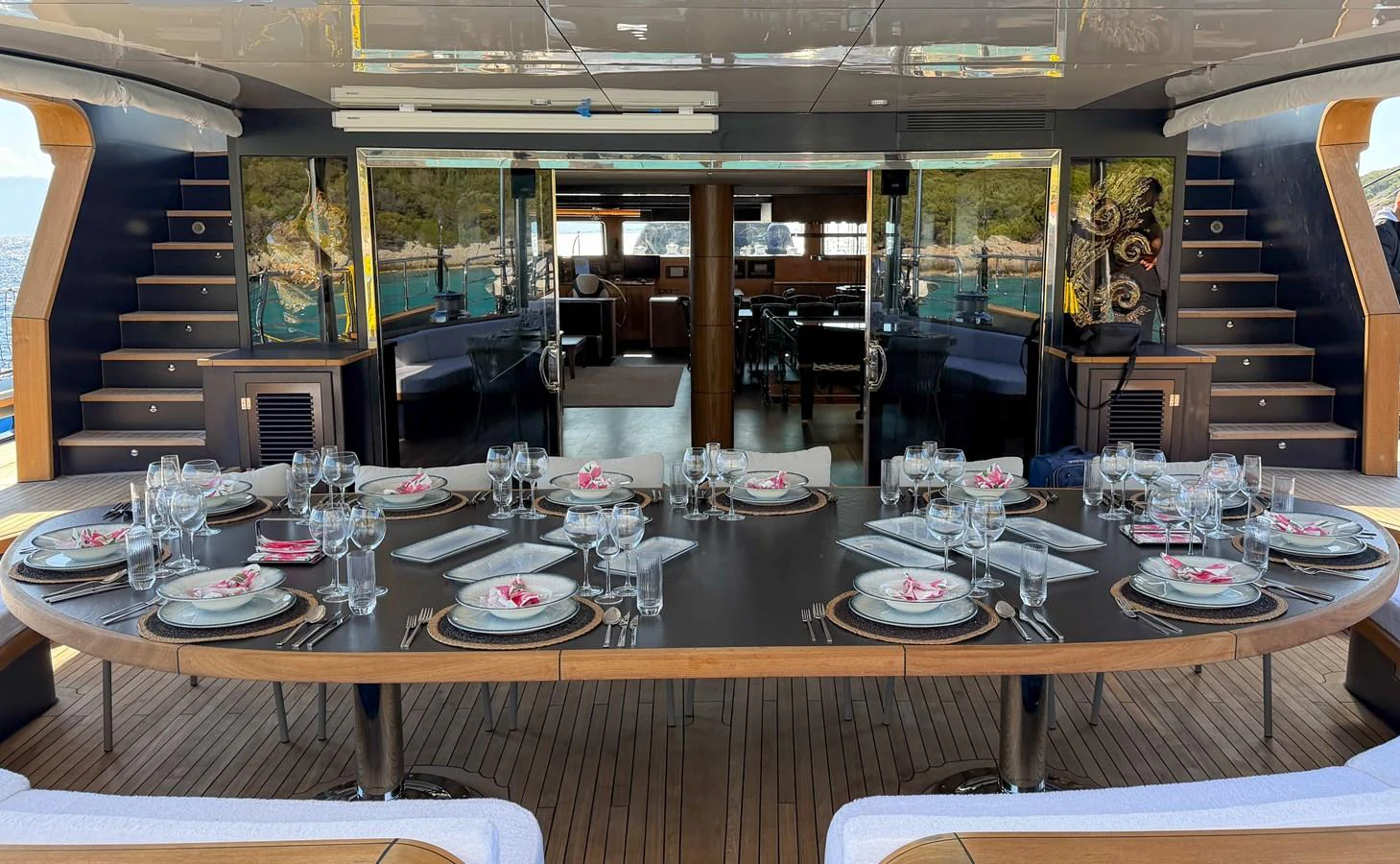 The aft deck features an elegant dining area set for a luxurious meal with a view. aboard OGUZ KHAN Yacht for Sale