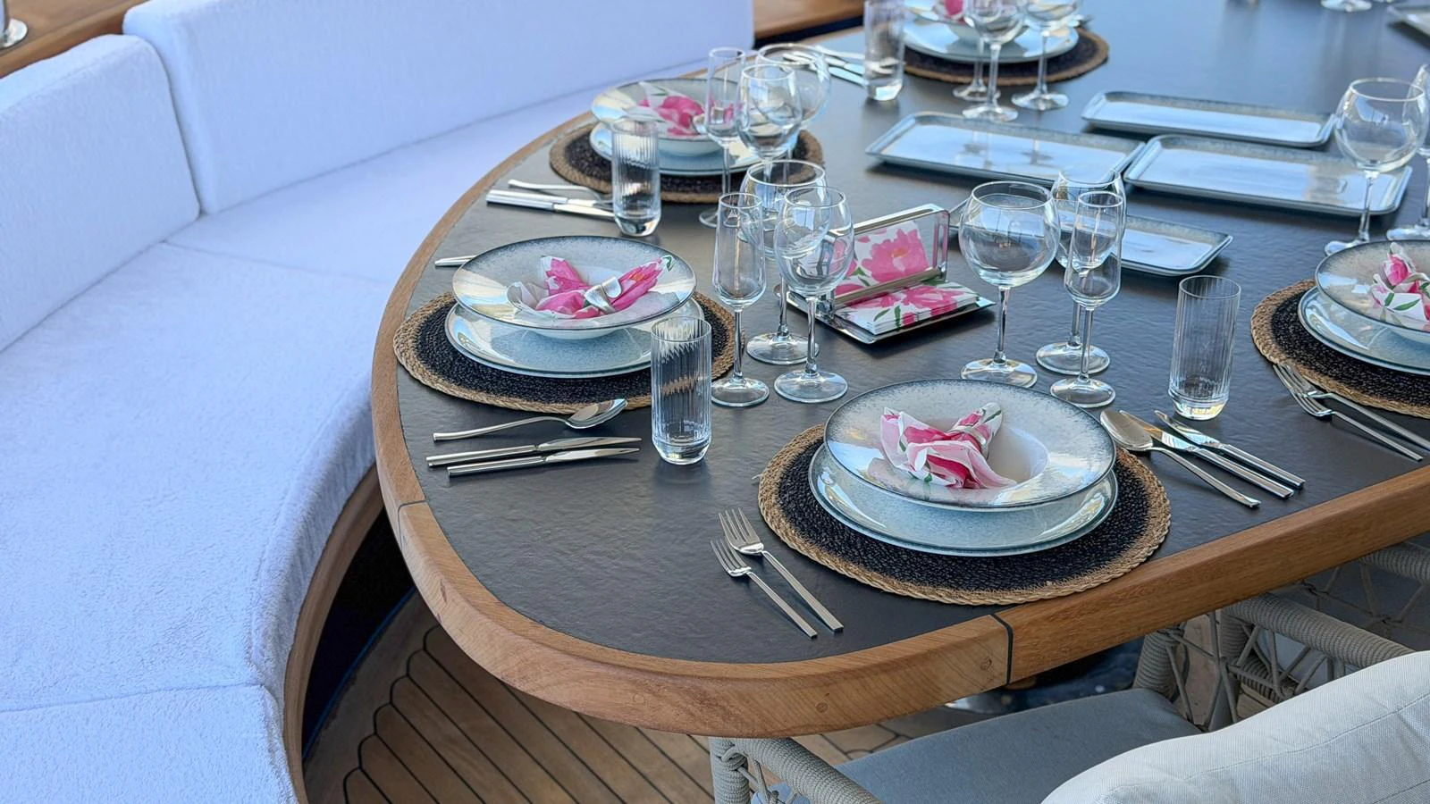 The yacht features an elegant dining area with a beautifully set table, perfect for alfresco meals. aboard OGUZ KHAN Yacht for Sale