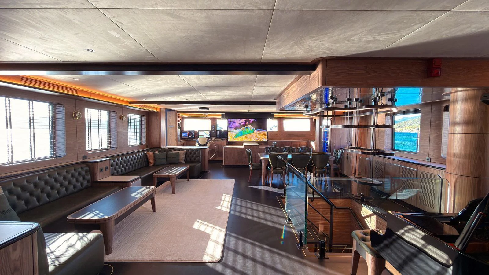 The spacious salon features elegant seating, a large flat-screen TV, and ample natural light. aboard OGUZ KHAN Yacht for Sale