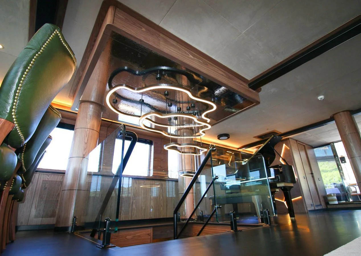The interior of the yacht features a modern design with luxurious furnishings and a stylish staircase. aboard OGUZ KHAN Yacht for Sale